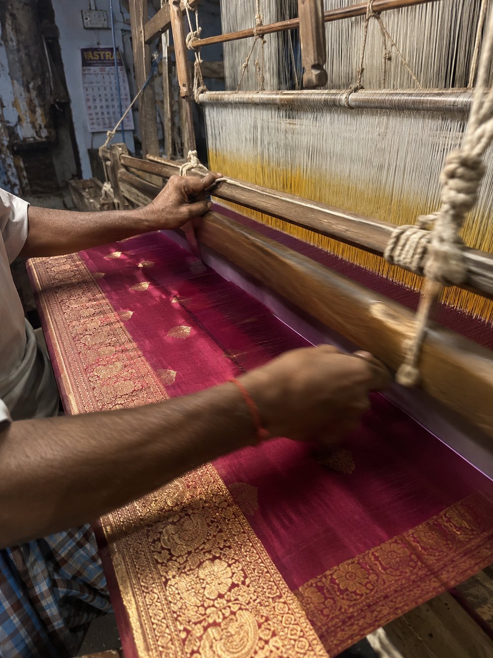 A weaver working a real Banarasi silk saree by hand on a traditional loom